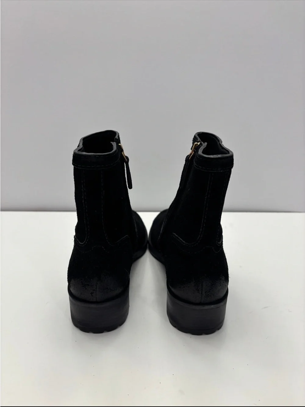 Tory Burch black suede Eloise flat booties with a prominent gold-tone metal logo